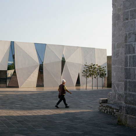 Concrete-clad sports hall by Idis Turato with both faceted and bumpy facades