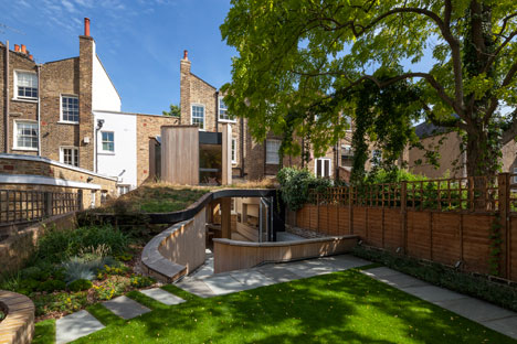 Curvy timber extension by Scott Architects features a sloping grass roof