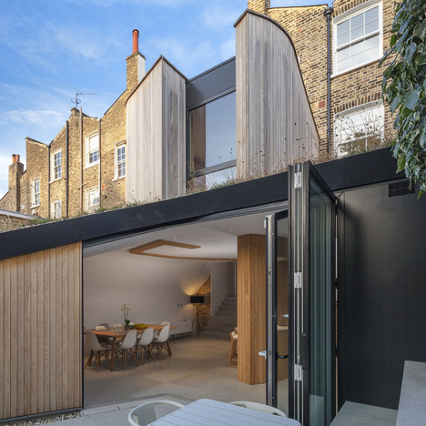 Curvy timber extension by Scott Architects features a sloping grass roof