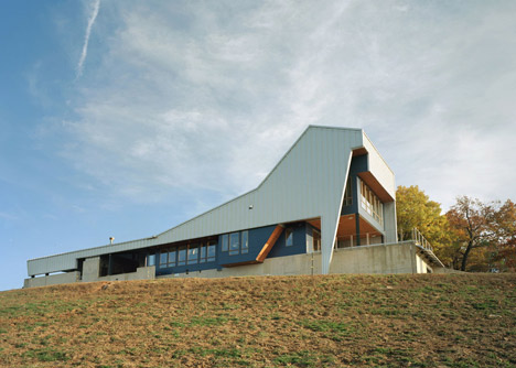Angular metal roof wraps around a hilltop house by deMx architecture