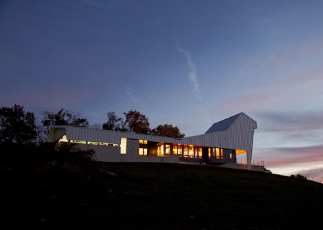 Angular metal roof wraps around a hilltop house by deMx architecture