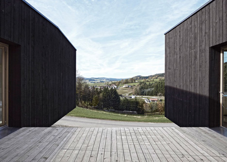Black-painted S House by Hammerschmid Pachl Seebacher raised up on stilts