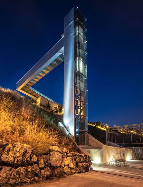 A steel-clad outdoor elevator connects the city and suburb in Pamplona by AH Asociados