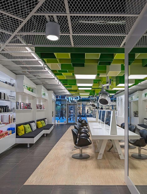 Green boxes cover the ceiling of Clip Drop In hair salon by Sweco Architects