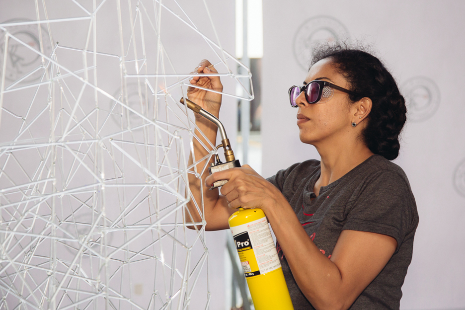 Anjali Srinivasan builds her Archway installation of glass rods at Dubai Design District
