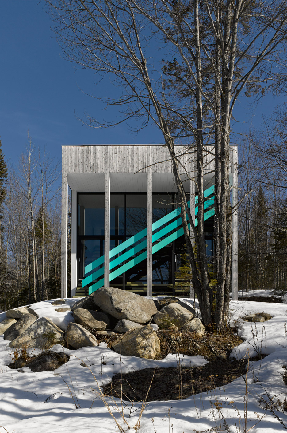 Turquoise staircase creates diagonal stripes across Quebec home by Architecturama