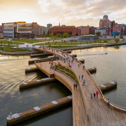 Curved pedestrian bridge links two riverfront parks in Providence