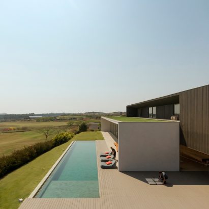 Green roof blends Brazilian house by Studio Arthur Casas with nearby golf course