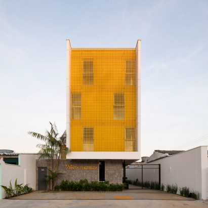 Yellow grates filter light into apartment building by Laurent Troost Architectures