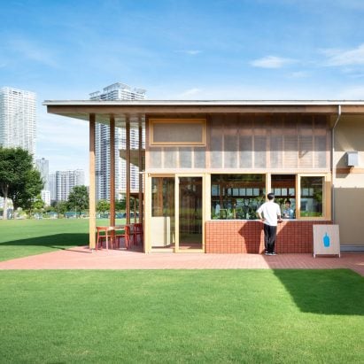 Wooden pillars support Blue Bottle Coffee cafe overlooking Tokyo Bay