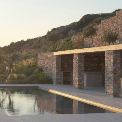 Rough drystone walls frame sunken home on Greek island by Alexandre Pavlidis