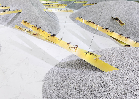 Golden girders protrude from piles of gravel to display sunglasses