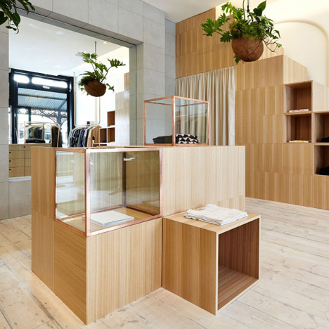 Kloke shop interior features copper clothes rails and wooden display units by Sibling