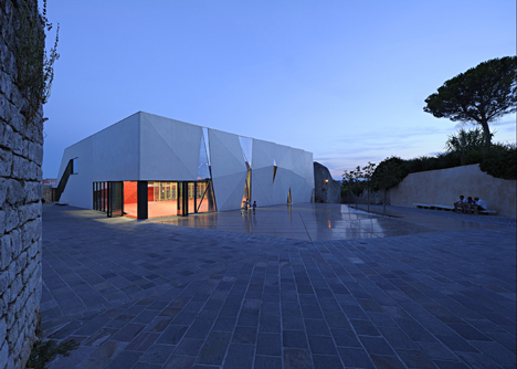 Concrete-clad sports hall by Idis Turato with both faceted and bumpy facades
