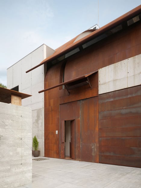 Pivoting steel doors lead into Studio Sitges, a house and photography studio in Spain by Olson Kundig