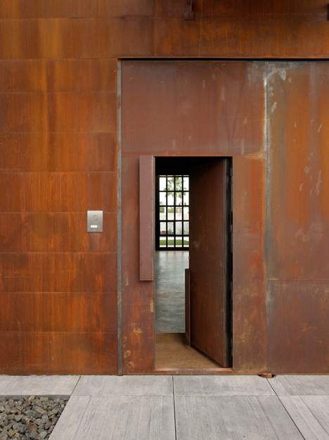 Pivoting steel doors lead into Studio Sitges, a house and photography studio in Spain by Olson Kundig