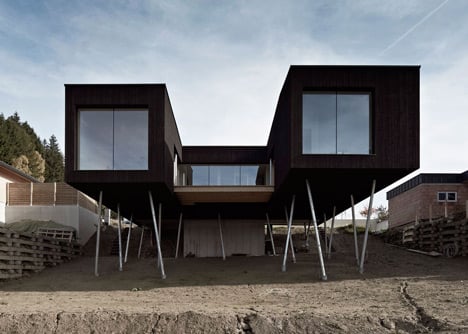Black-painted S House by Hammerschmid Pachl Seebacher raised up on stilts