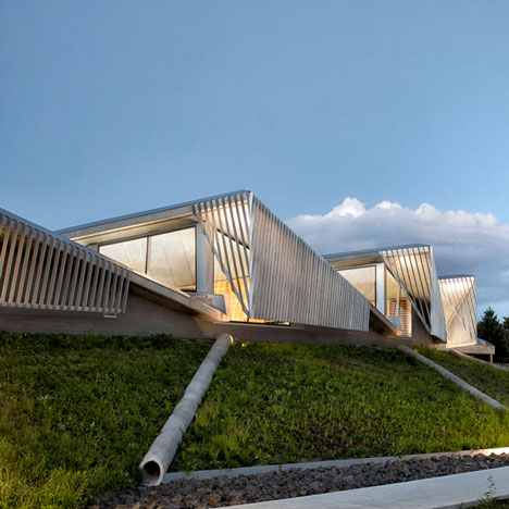 Water treatment facility by Skylab Architecture features a roof of grass-covered fins