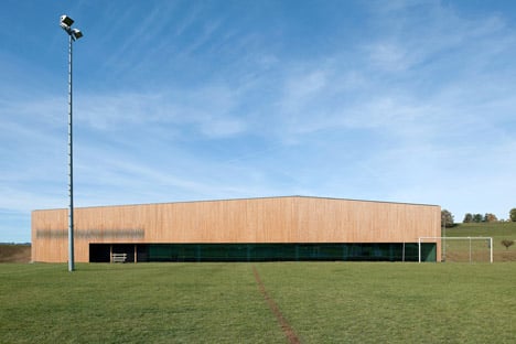 Timber walls feature narrow vertical slices at Virdis Architecture's Lussy Sports Hall