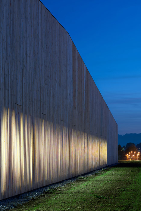 Timber walls feature narrow vertical slices at Virdis Architecture's Lussy Sports Hall