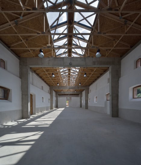 3+1 Architekti converts a stone barn into a woodwork facility with a serrated timber extension