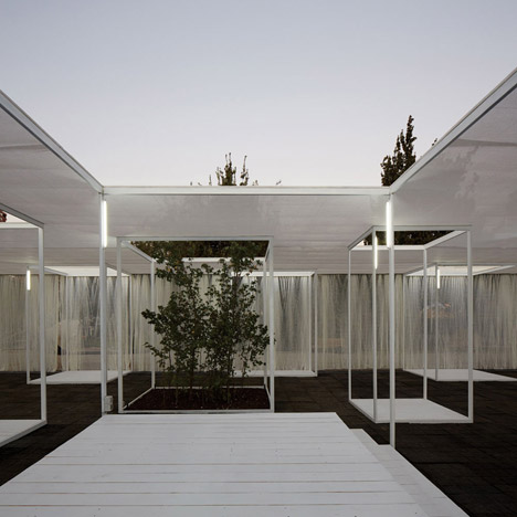 Trees and exhibition stands line up with skylights inside Umwelt's Ambient 30_60 pavilion