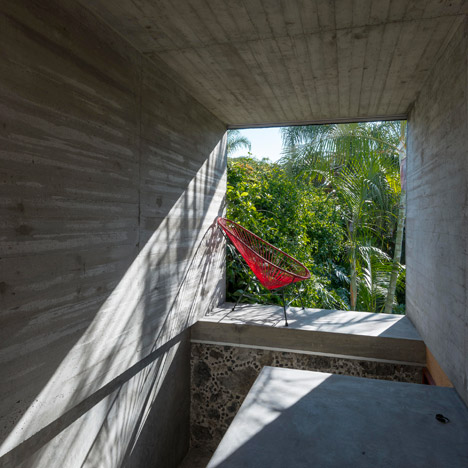 Concrete tunnel extends through an old stone wall at Leyva 506 house by APT