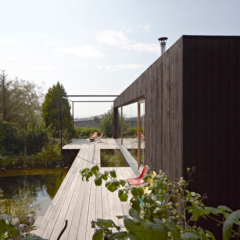 Black house by Hammerschmid Pachl Seebacher is raised above a bathing lake