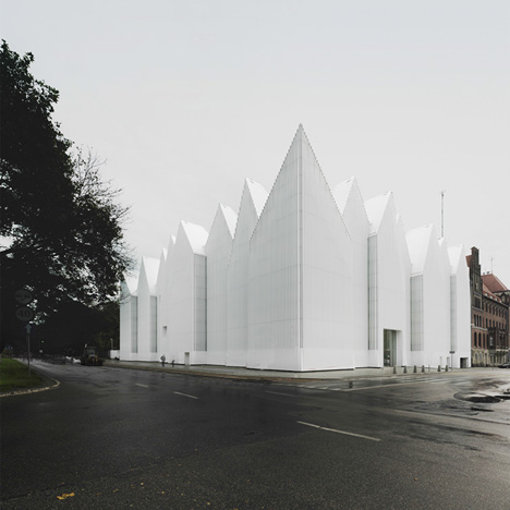 Translucent glass concert hall designed by Barozzi Veiga with a jagged roofline