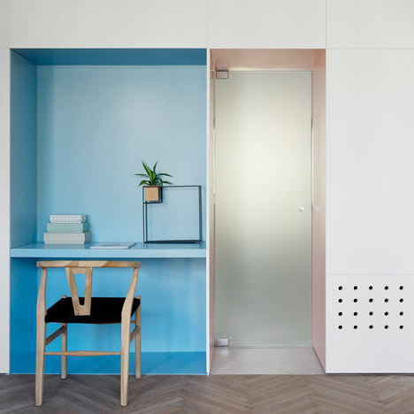 Wall of hidden panels provides storage for renovated Tel Aviv apartment
