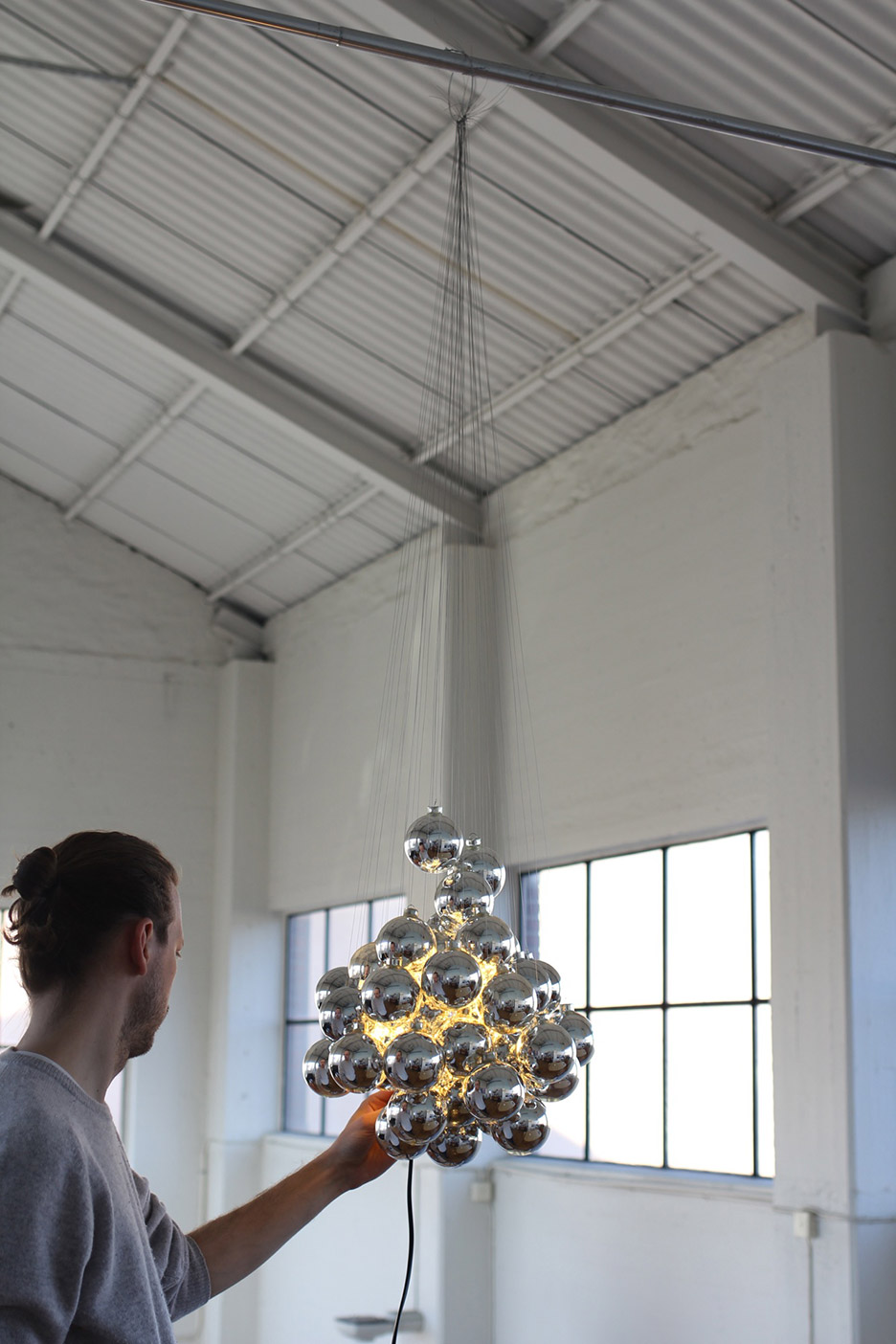 Daniel Rybakken stands with his Stochastic lamp for Luceplan