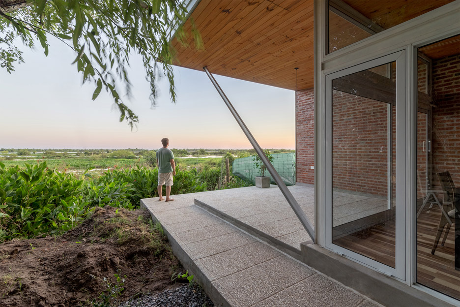 House 50 50 by Celula Urbana sits next to a river in Argentina