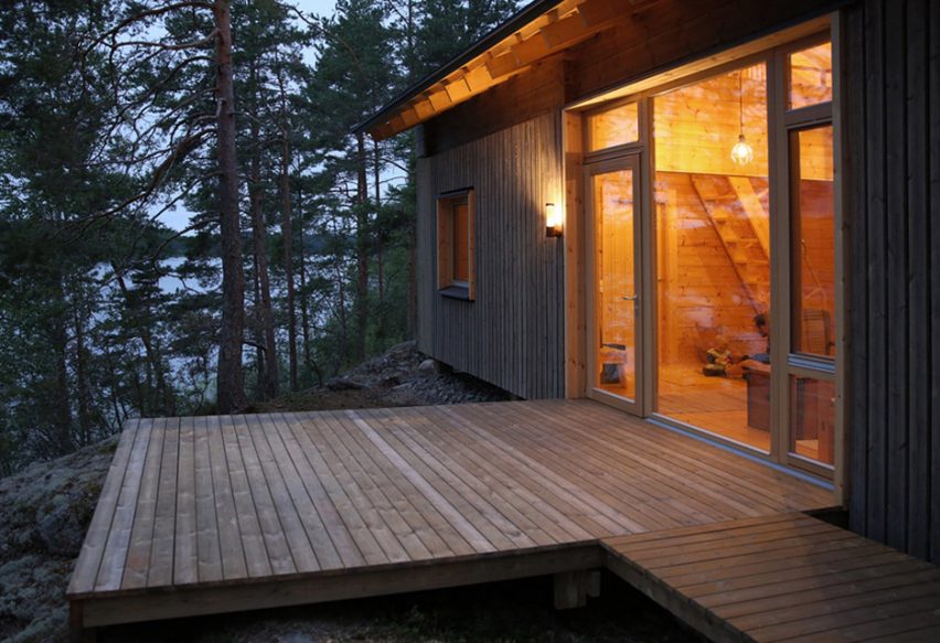 Lake cabin by Sini Kamppari features slatted timber siding and projecting terrace