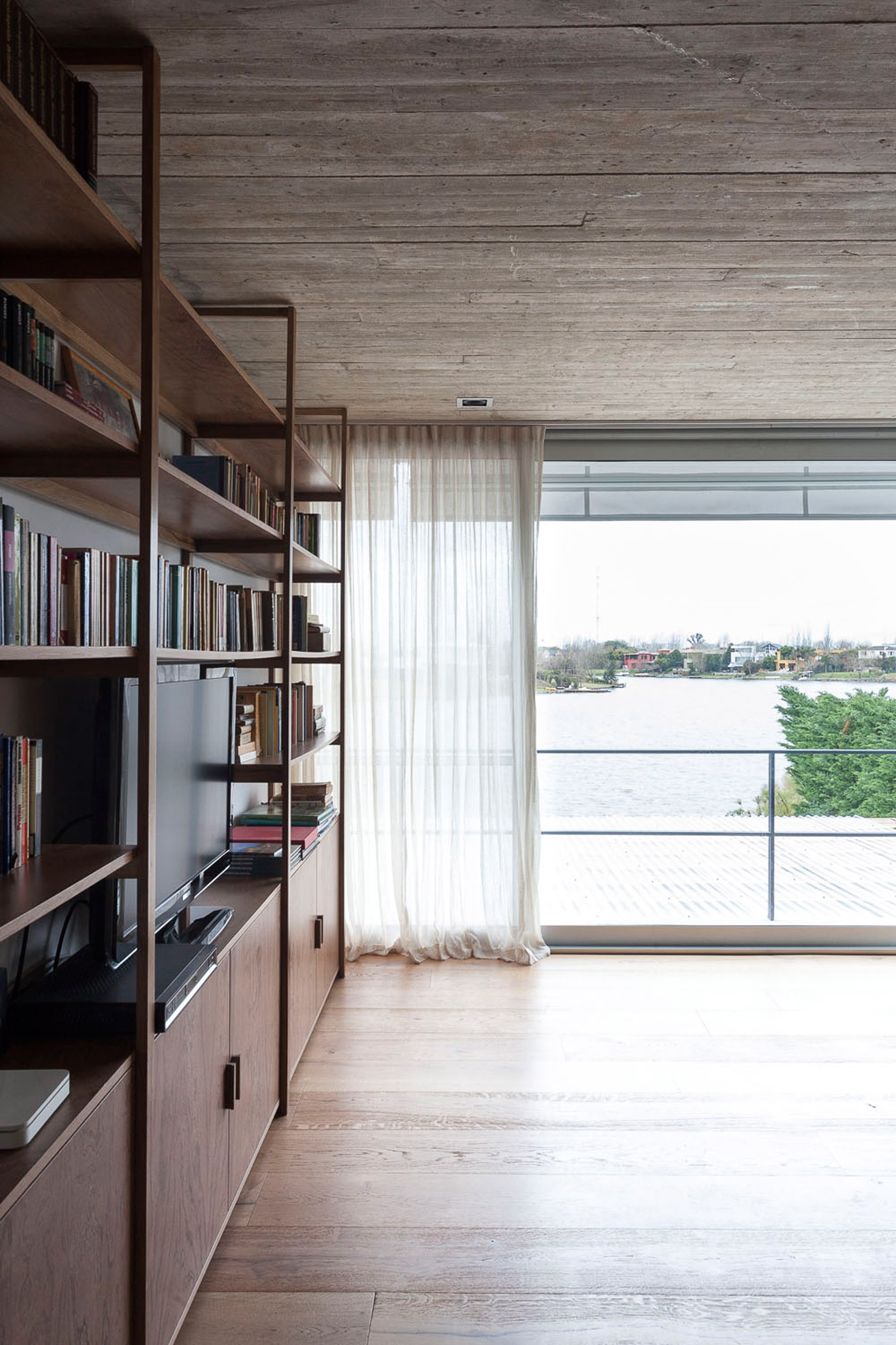 Textured concrete walls frame lake views from Buenos Aires house by Federico Sartor