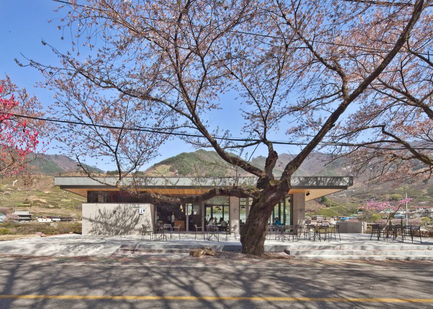Rooftop bridge connects riverside house and roadside cafe in a South Korean valley