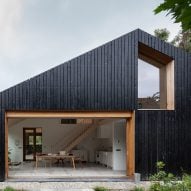 Blackened wood barn by Workshop Architecten houses both livestock and people