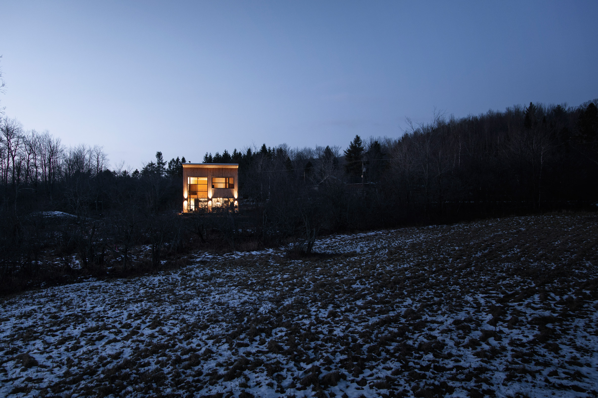 Canadian winter home designed by Atelier L'Abri looks like it is covered in  snow in the forest