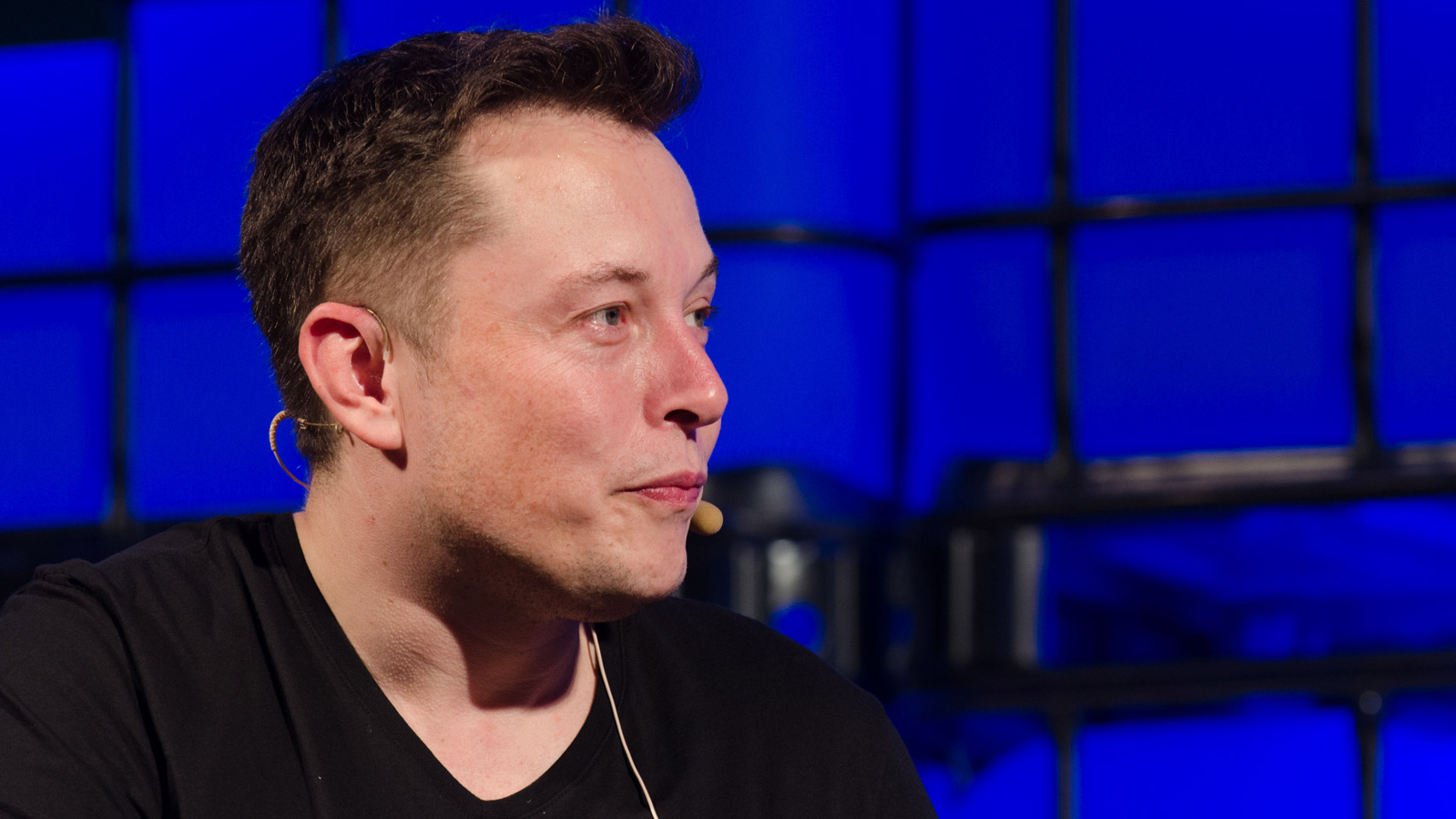 Elon Musk against blue background