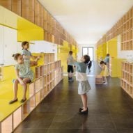 Walls with integrated furniture and yellow nooks encourage play in Madrid school