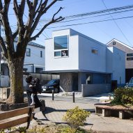 Bright white living spaces overhang gallery in top-heavy Tokyo house by Form