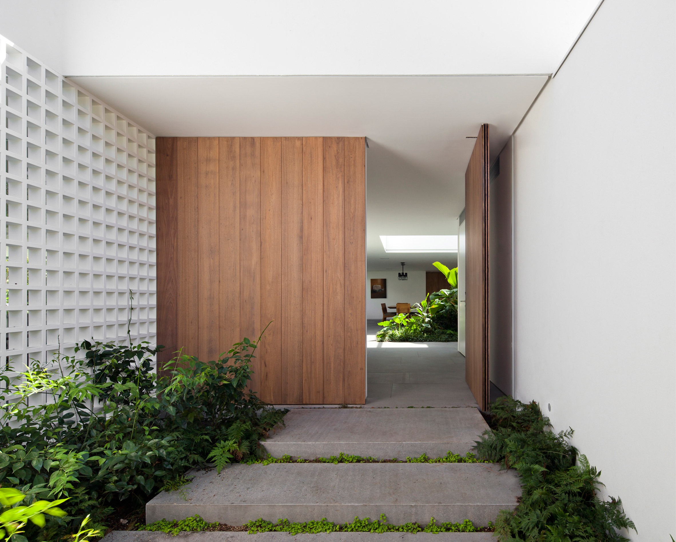 Plant-filled courtyards create natural enclaves in Brazilian home by AZM Arquitetos