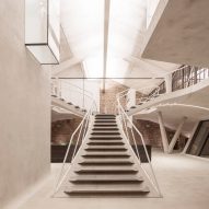 Smartvoll adds sculptural concrete staircase to loft apartment in old Salzburg tank station