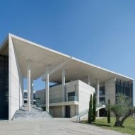 Angled walls and fissures break up mass of concrete office building by Vtria Architects