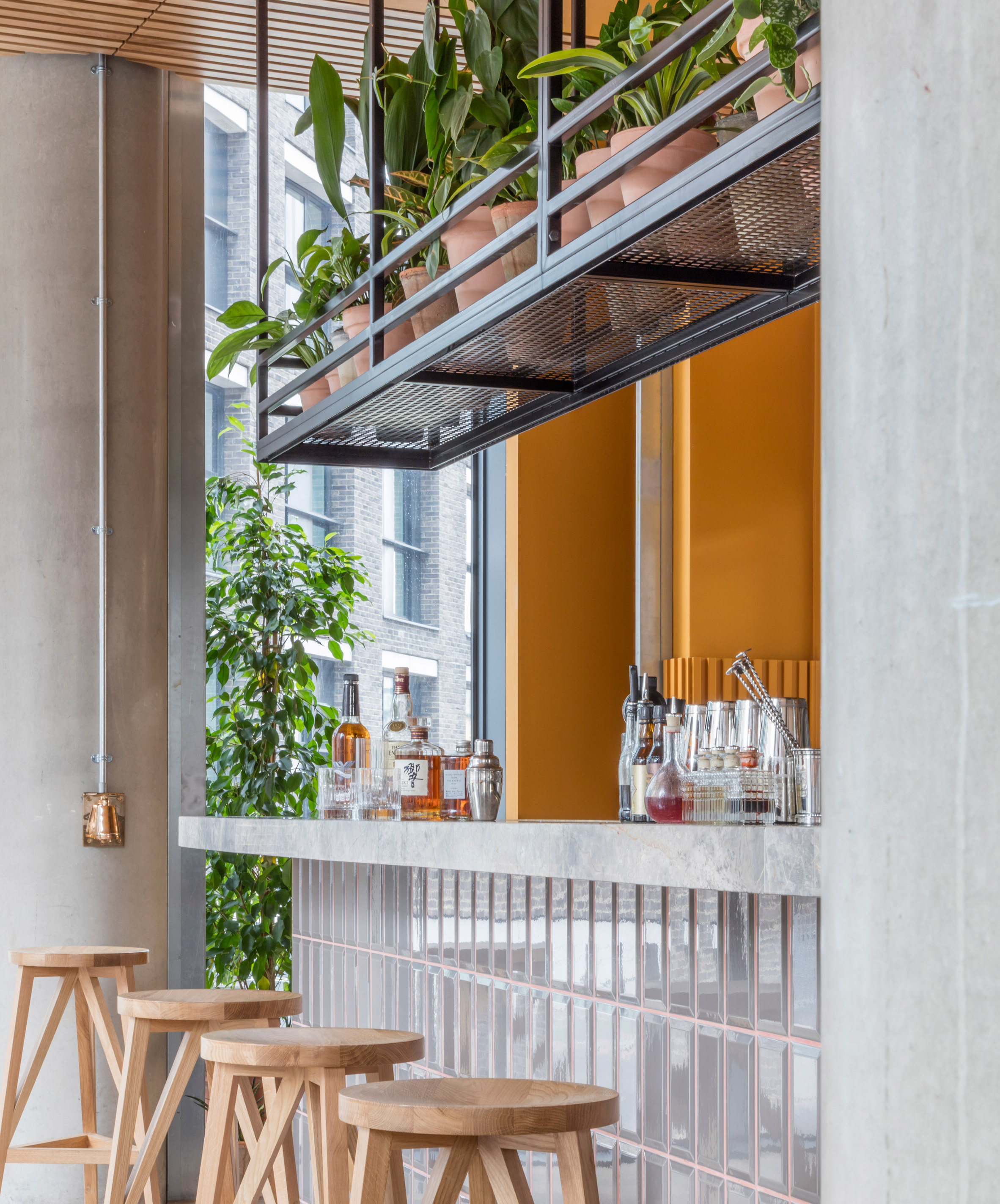 Cement grey meets bright ochre in Grzywinski + Pons' London restaurant interior