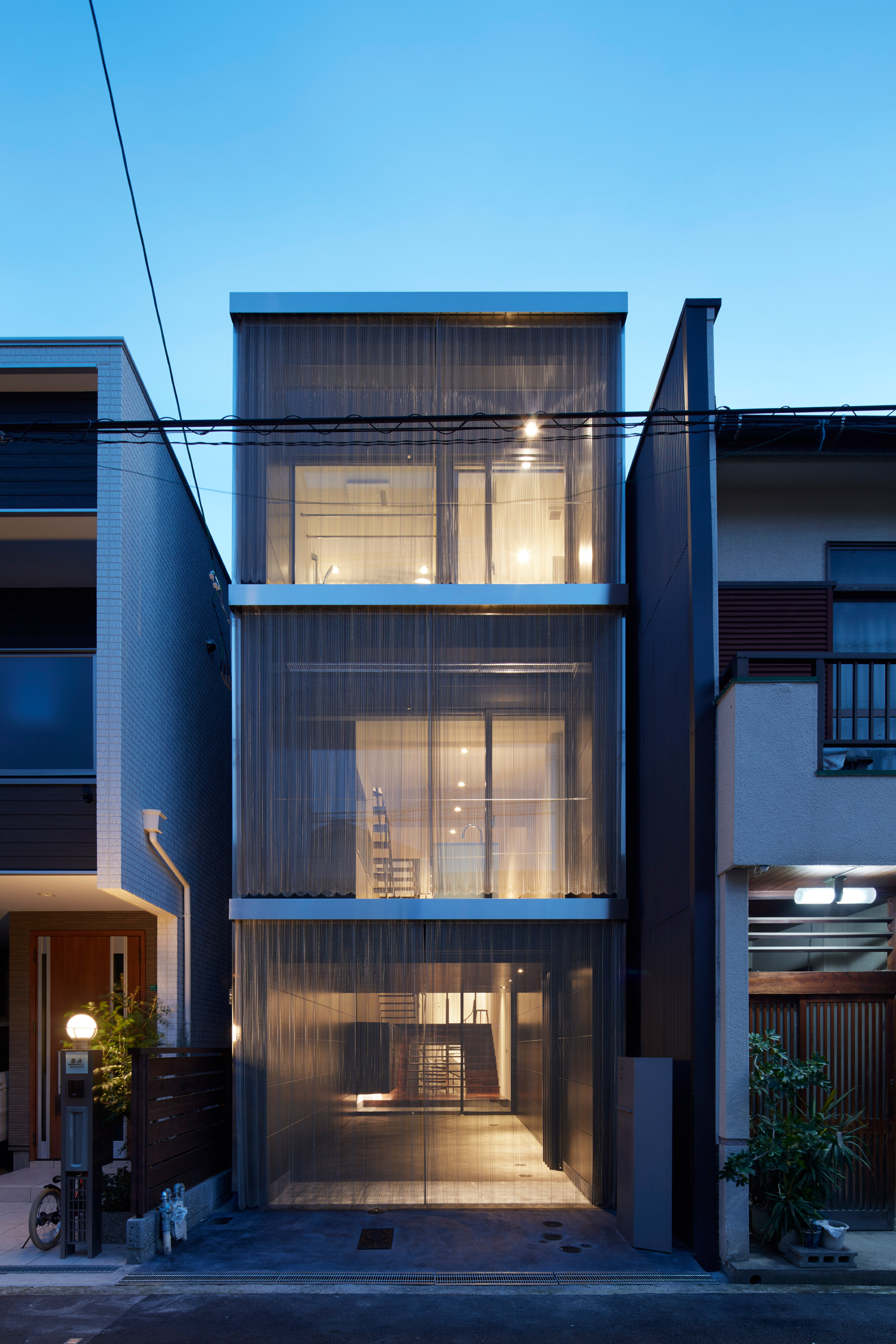 KC Design Studio adds perforated facade and atrium to skinny