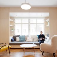Clever storage surrounds window seat in Prague flat renovated by Atelier 111 Architekti