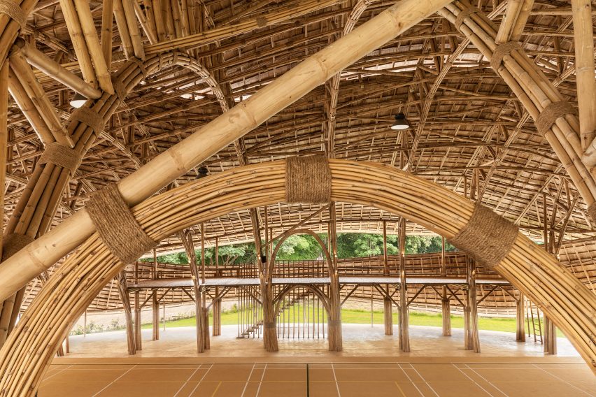 Arching bamboo trusses are left exposed in Chiang Mai sports hall