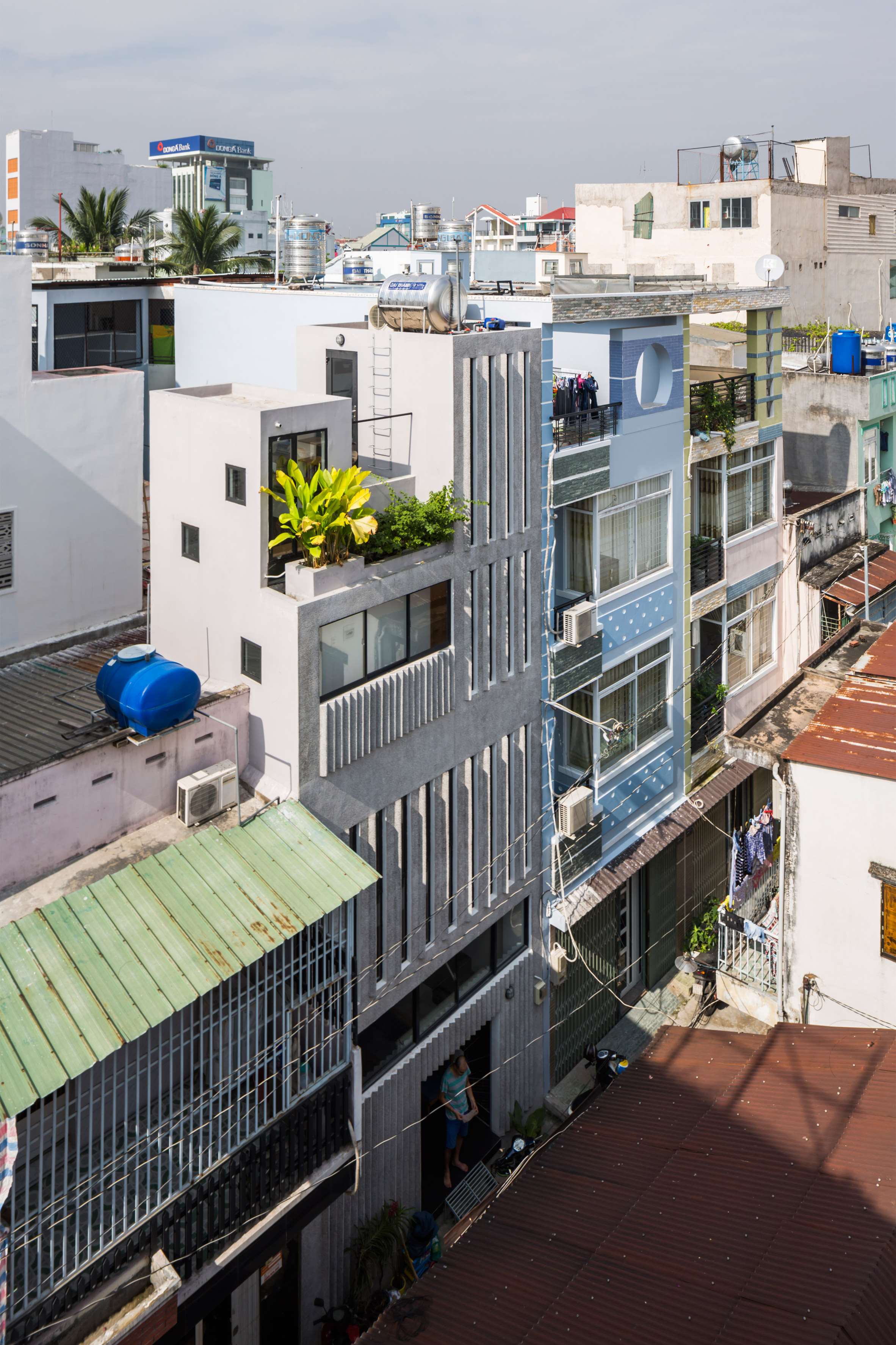 Narrow windows allow daylight into terrazzo-covered house in Ho Chi Minh City