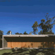 Slatted timber doors unfold along house in Uruguay by Masa Arquitectos