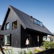 Chris Collaris Architects completes black wooden cottage with exaggerated roof